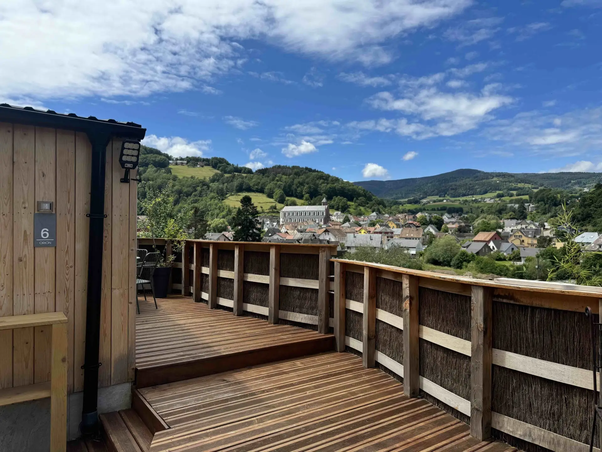 Terrasse en bois avec vue dégagée sur le village et les Vosges, Tiny House Orion
