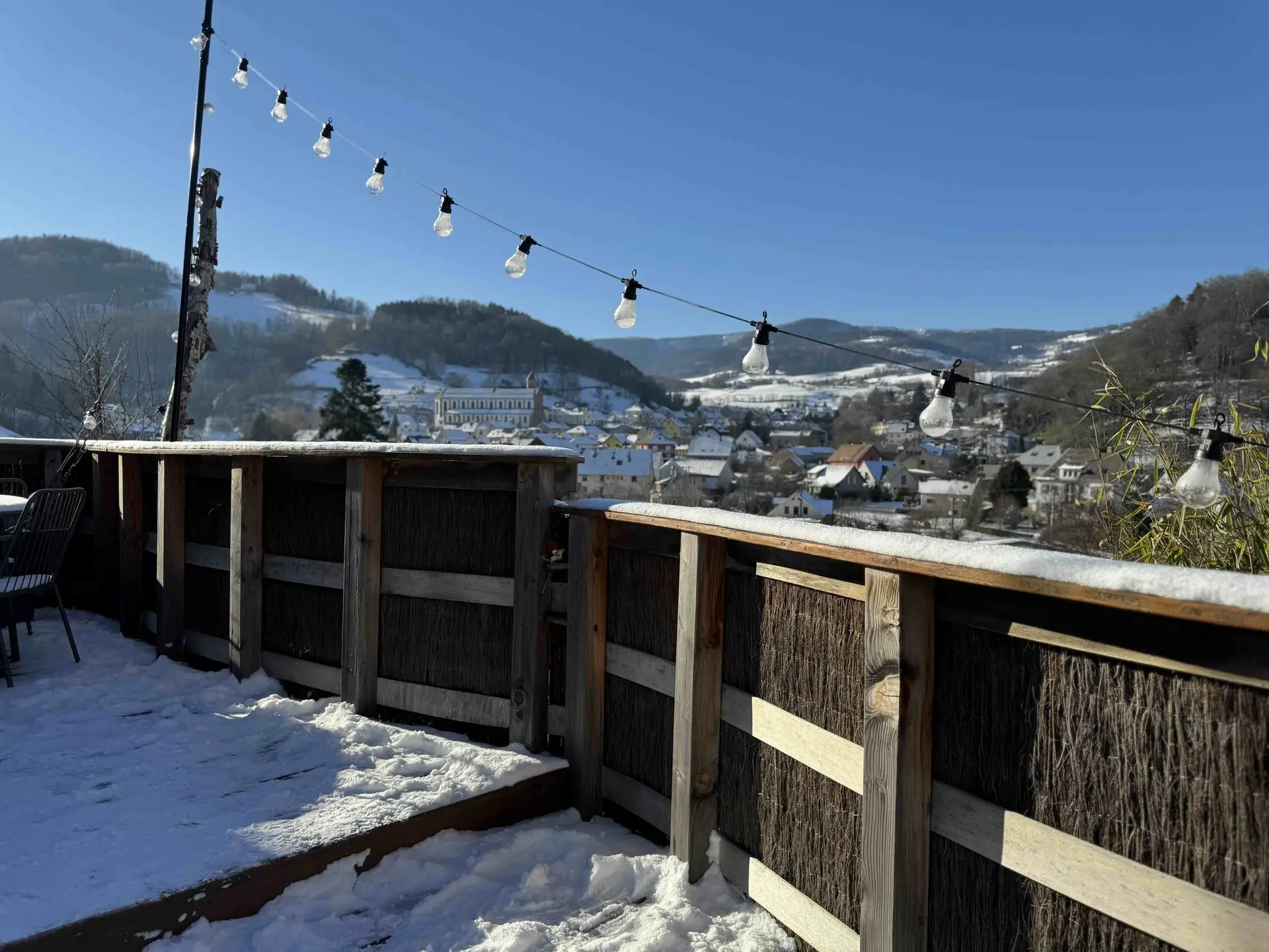 Vue sur le village et les Vosges enneigées depuis la terrasse, Tiny House Orion