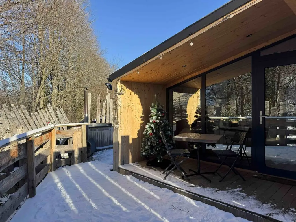 Terrasse enneigée avec sapin décoré, Tiny House Petite Ourse, Alsace en hiver
